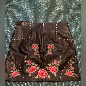 Short leather skirt with flower detail on the front with beads.